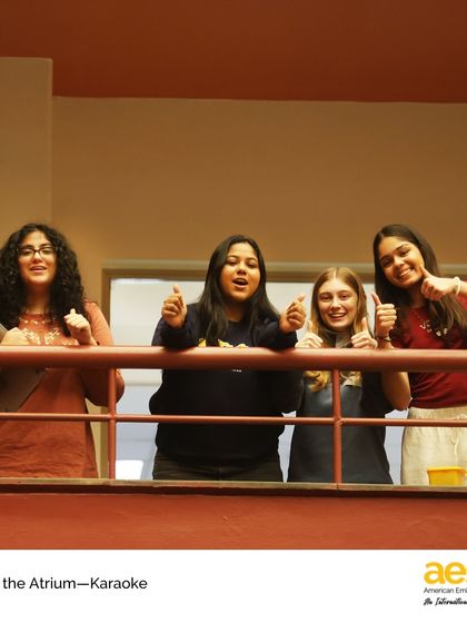The audience gives a thumbs-up from the balcony during a great karaoke performance. The supportive atmosphere is a hallmark of our community.