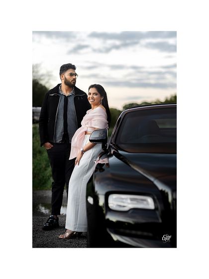 A cool, edgy shot with a Rolls Royce. Their coordinated outfits, featuring a mix of textures and modern silhouettes, create a high-fashion feel for their London pre-wedding shoot.