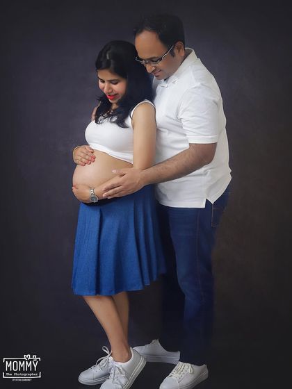 A tender moment between an expecting couple. The way he looks at her and they both gently hold the baby bump shows all the love and anticipation they share.