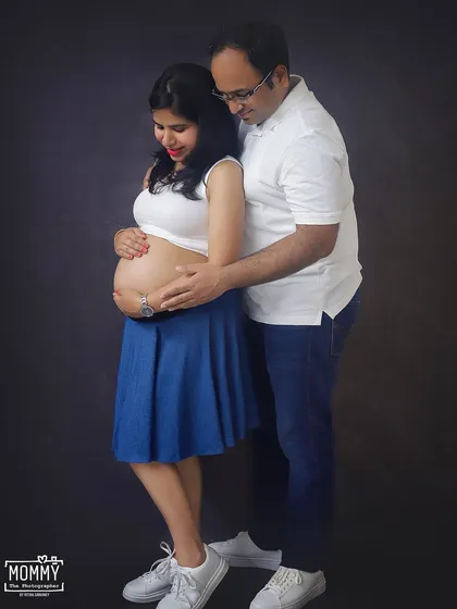 A tender moment between the expecting parents. This casual studio portrait in jeans and white tops feels so natural and full of love.