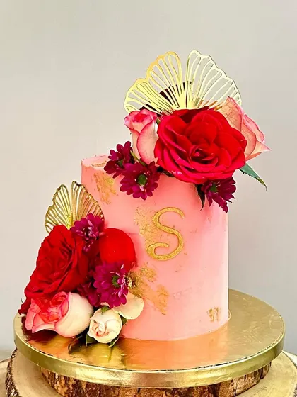 A full view of the tall pink monogrammed cake, a perfect example of a modern, chic birthday celebration cake.