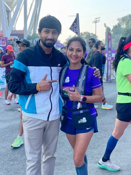Pointing to a fellow runner's bib. Every participant in a marathon is on their own journey, and I respect and support them all.