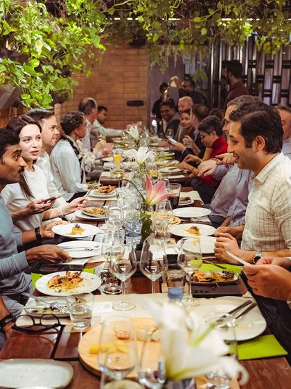A full view of the long table at our wine tasting event, showing a vibrant and engaged crowd.