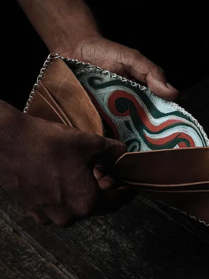 The reveal of a custom-printed leather wallet, showcasing the fusion of traditional leatherwork and printmaking. We host workshops where you can learn to craft your own unique leather goods.