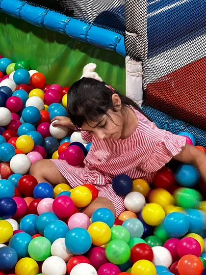 Diving into a sea of colorful balls! The ball pit is a sensory delight for our youngest guests.