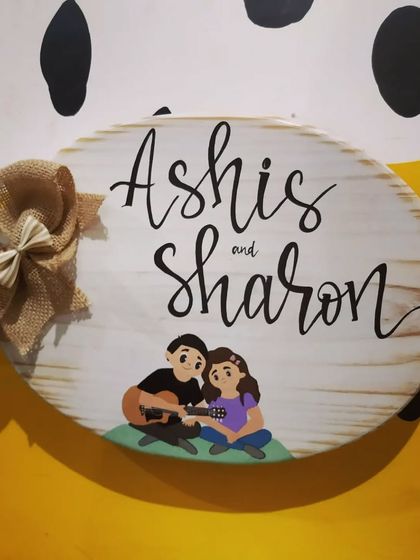 The "Ashis and Sharon" plaque displayed against our studio's vibrant yellow and polka-dotted wall, showing its cheerful character.