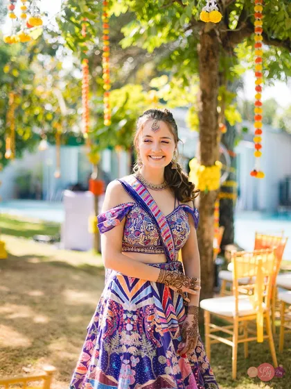 The bride, Nelya, glowing with happiness at her vibrant and colourful Haldi event. Her multicoloured lehenga perfectly matched the joyful atmosphere.
