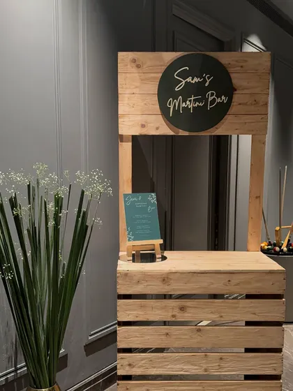 The rustic martini bar setup, ready for the party. This custom station adds a fun, interactive element for guests and enhances the overall theme of the event.