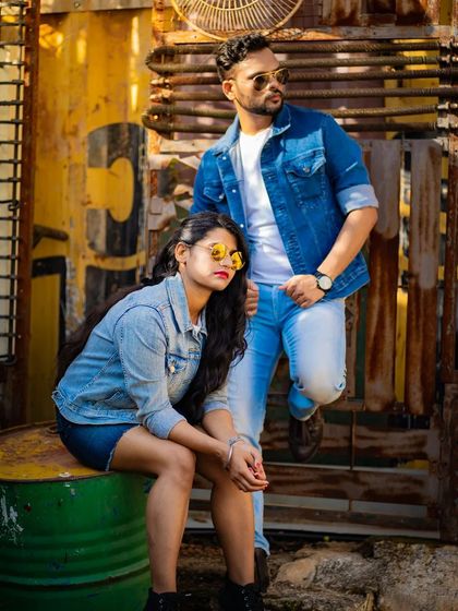 Another shot from the industrial-themed session, highlighting the couple's confident poses and coordinated style against a textured, yellow background.