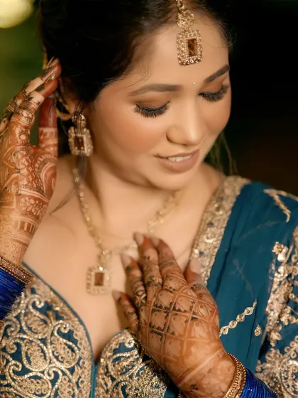 A close-up of the bride's hands, showcasing the intricate henna design and her elegant jewelry. I believe the beauty of a wedding is in the details, and I make sure to capture every element of your bridal look.