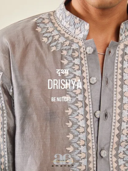 A macro shot of the embroidery on the grey Chanderi kurta, with our brand motto "Be Noticed".