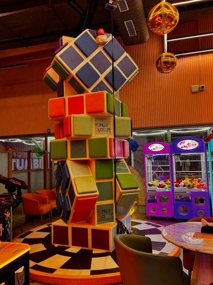 A look at our colorful and fun decor, including a giant Rubik's cube structure and classic claw machines in our arcade area.