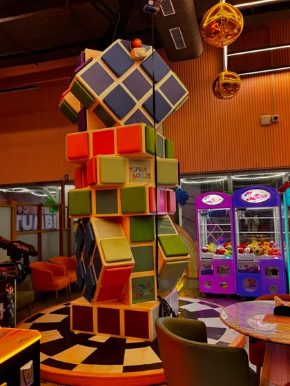 A look at our colorful and fun decor, including a giant Rubik's cube structure and classic claw machines in our arcade area.