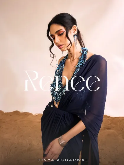 The Renee Saree Set, a sight to behold. The deep blue and gold combination with a heavily embellished halter blouse is perfect for a glamorous evening.
