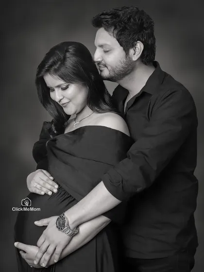 An intimate black and white portrait showing the deep bond between partners. The focus is on their gentle touch and loving expressions, creating a photo full of warmth and anticipation.
