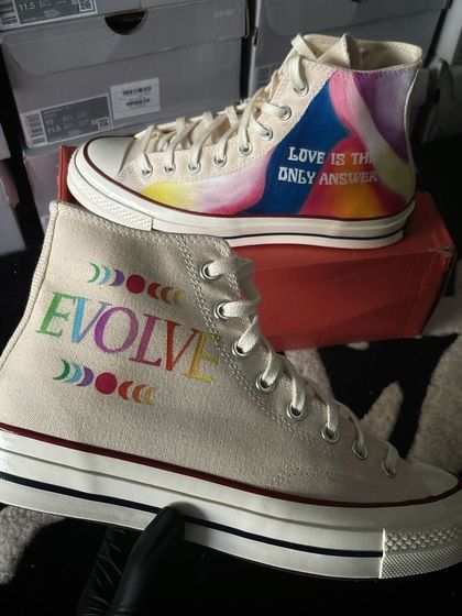 A pair of Converse Chuck 70s with a colorful, abstract "Evolve" and "Love is the only answer" design.
