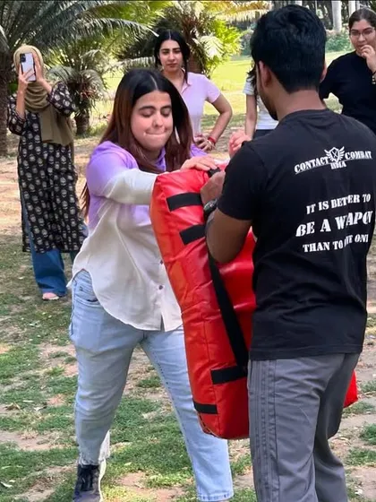 Another student practices her strikes during the outdoor workshop. Each punch builds confidence and skill.