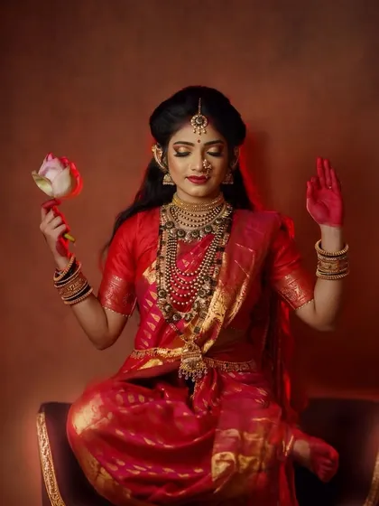 A serene portrait capturing the meditative grace of the Goddess, holding a lotus flower as a symbol of purity and enlightenment in this studio concept shoot.