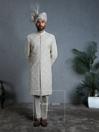 This ivory sherwani, adorned with 3D florals, reflects not just style, but the blessings and royal pride of a groom. The full ensemble is a testament to detailed craftsmanship.