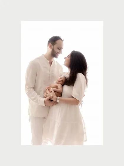 A color version of the first family portrait, showing the warmth and tenderness between new parents and their baby. The all-white clothing and bright studio light create a feeling of purity and new beginnings.