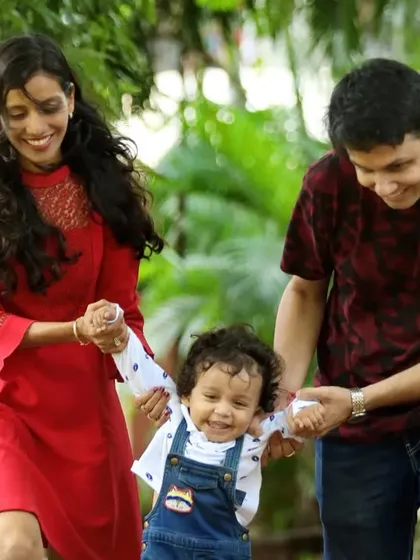 Capturing a toddler's first steps with the help of mom and dad during a relaxed outdoor park session. This is an example of our candid photography style, preserving authentic family milestones as they happen.