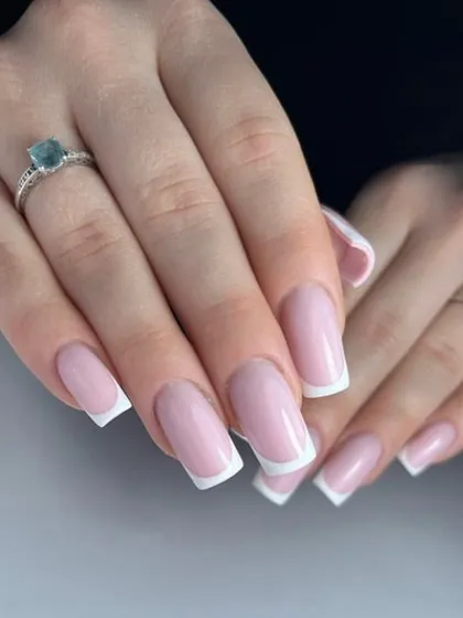 A perfectly executed classic French manicure on medium-length square nails, showing how this elegant design works beautifully on different lengths.