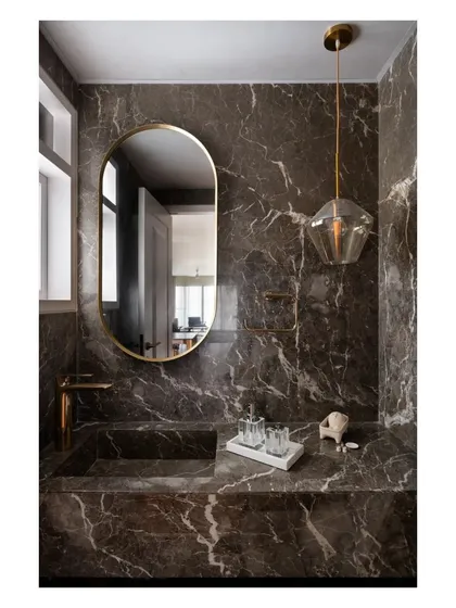 I believe bathrooms should be immersive sanctuaries. In this space, I used dramatic, book-matched marble to clad the walls and form an integrated sink. The result is a monolithic and luxurious retreat that feels carved from a single block of stone.