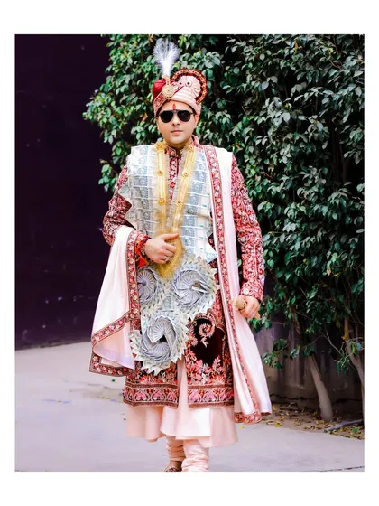 A portrait of the groom in his traditional wedding attire, complete with a sehra made of currency notes. This shot captures a classic element of North Indian weddings.