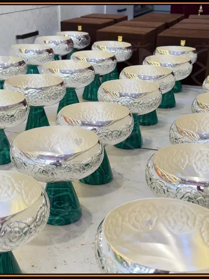 Preparing a bulk order of these stunning silver-coated bowls with a green marble-finish base. Their timeless elegance makes them a popular choice for luxe wedding return favors.