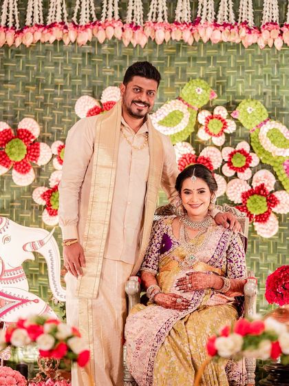 A couple at their baby shower. Her beautiful green and purple saree is complemented by his traditional cream silk dhoti and kurta.