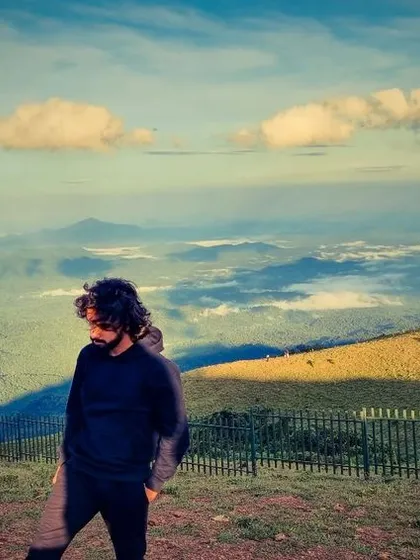 A candid shot of a traveler taking in the vast, cloud filled valleys of Coorg. These are the moments of quiet reflection our trips provide.