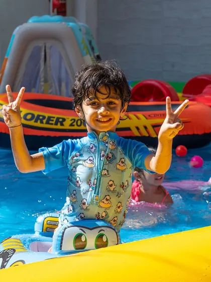 Peace and smiles all around. This little guy is having a fantastic time in his floatie, ready for more water adventures at our summer pool party.