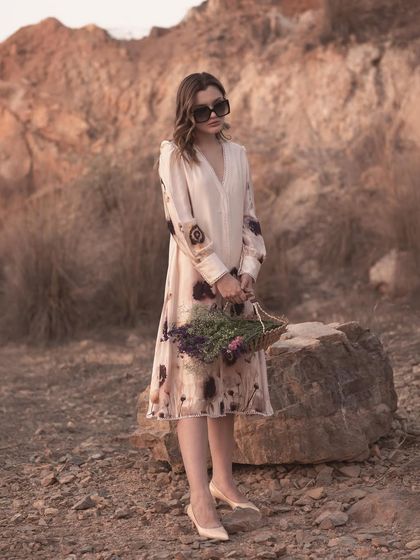 A similar pose to the previous shot but with a different angle, offering a clearer view of the dress's print and silhouette. Providing variations is key for a comprehensive lookbook.