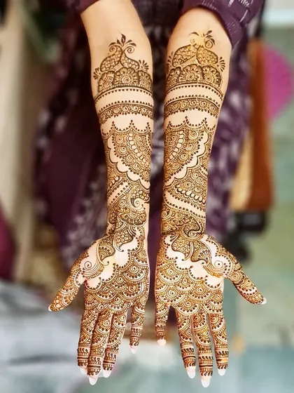 Elegant bridal henna for Tasneem, featuring beautiful scalloped edges and delicate patterns that flow from the fingers to the forearms.