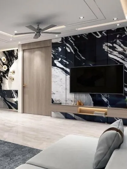 Another view of the living room, showing the striking contrast between the black and white marble wall and the light wood door. A unique, sculptural light fixture adds an artistic touch.