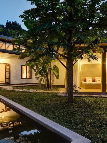 The Garden Suite at dusk, showing how the private courtyard becomes a tranquil, illuminated space. The design includes a separate garden daybed, creating a seamless flow between indoor and outdoor living.