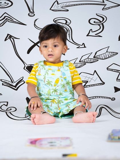 A creative doodle-themed backdrop adds a fun and artistic element to this toddler portrait.