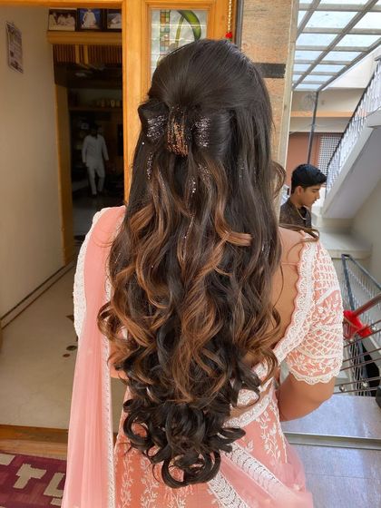 A fun and stylish look for a baby shower, featuring bouncy curls with highlights and a trendy claw clip.