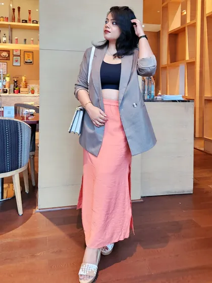This outfit demonstrates how to blend professional and chic elements. A structured grey blazer over a coral pink skirt creates a look that is both approachable and authoritative.