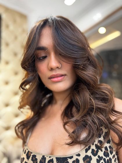 A close-up of the no-bleach balayage, showing the soft curtain bangs and beautiful blend of colors. This style is perfect for a modern, sophisticated look.