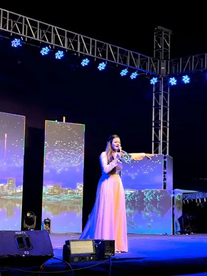 Another candid from the Sangeet stage, with the city skyline LED screen in the background.