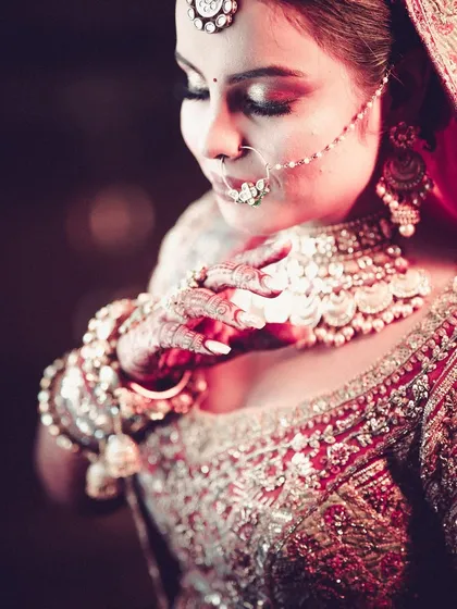 A close-up of the bride's intricate jewelry and makeup.