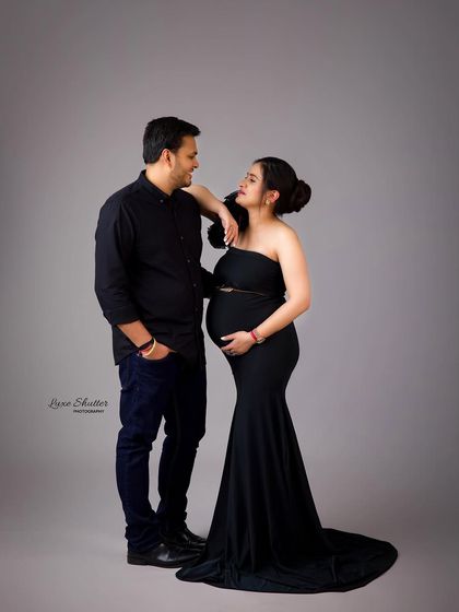 A sweet and classic couple's pose. Their matching black outfits create a timeless look, allowing their happy expressions to be the focus.