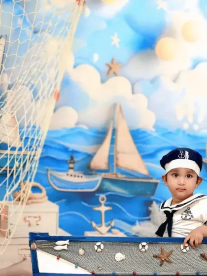 All aboard. A little sailor in a classic uniform poses in a boat, ready to set sail on a sea adventure.