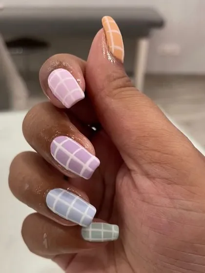 A trendy pastel rainbow grid pattern on matte coffin-shaped nails.