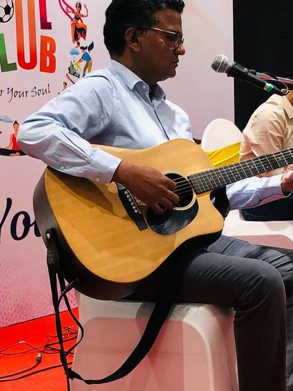 A participant from the Raymond team confidently plays the guitar on stage during the workshop. We encourage active participation to make the experience more impactful.