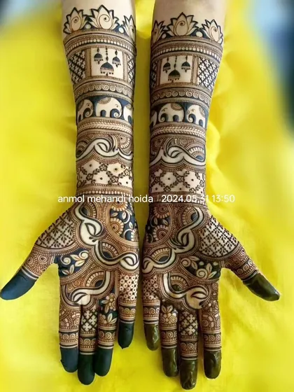 This design features bands of marching elephants and hanging jhumkas, creating a festive and royal look. The fingertips are fully covered in henna for that deep, rich bridal stain.