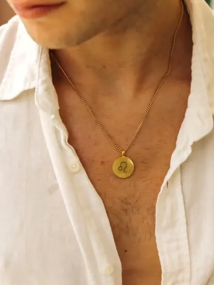My necklaces are for everyone. Here, a classic round gold pendant is engraved with the Leo zodiac sign, offering a stylish way for him to connect with his astrological identity.