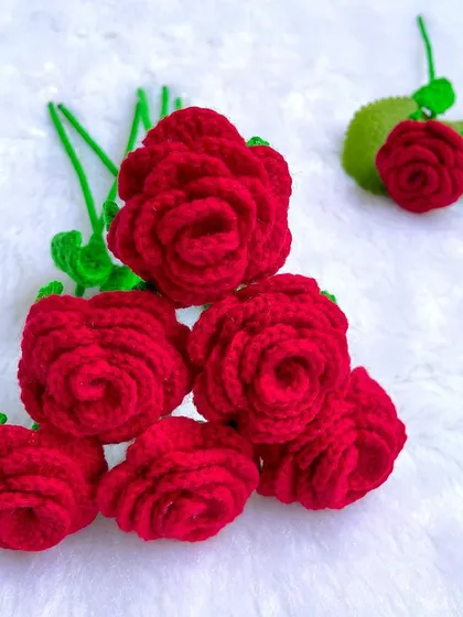The heads of the seven crochet roses, showing their beautiful, layered petal design before being attached to their stems.