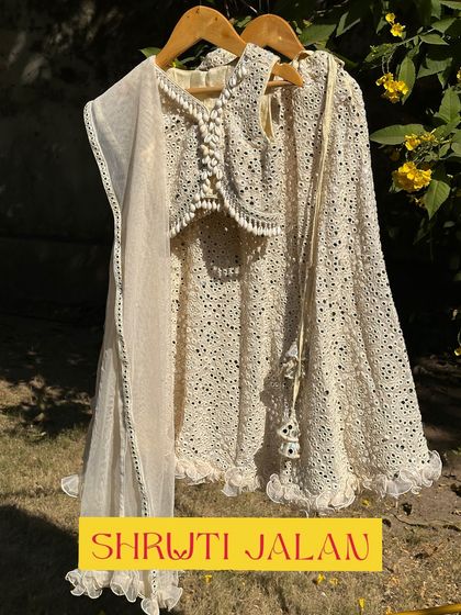 Here is my cream-colored mirror-work lehenga, a timeless and elegant choice for any wedding. The delicate tassels and soft net dupatta complete this graceful look.